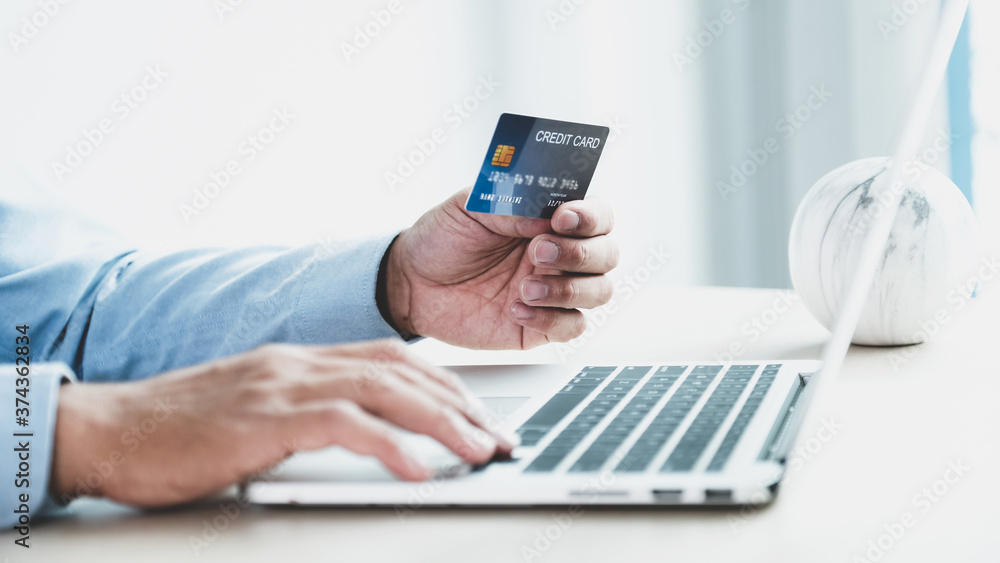 Businessman hand holding credit card to online shopping from home, payment e-commerce, internet banking, spending money for next holidays Businessman hand holding credit card to online shopping from home, payment e-commerce, internet banking, spending money for next holidays