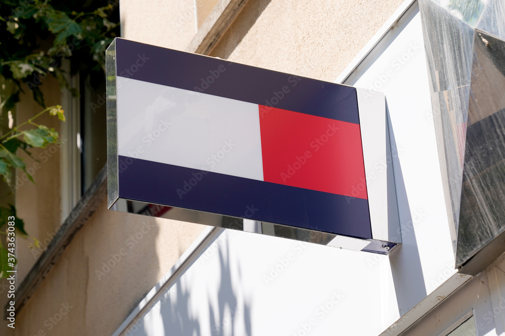 Tommy Hilfiger logo store front of brand premium American clothing company  sign shop Stock Photo | Adobe Stock