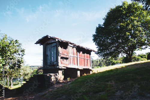 old wooden narrow house on top of a hill against blue sky photo