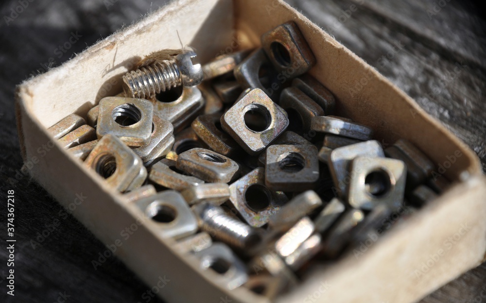 Closeup view nuts and screws in Matchbox Various metal details in cardboard box Closeup view nuts and screws in Matchbox Various metal details in cardboard box