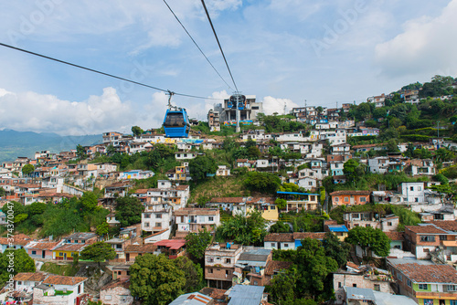 Cali, Valle del Cauca, Colombia. May 17, 2018: Blue cab of MIO transport system and houses with colorful facades. photo