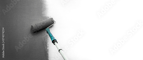 Close up roller with gray paint for painting walls. Repairs. White wall. Background. Screensaver for the site. High quality photo
