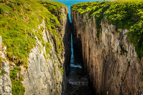 The deep crevice of  Huntsman Leap  on the Pembrokeshire coast  Wales in early summer