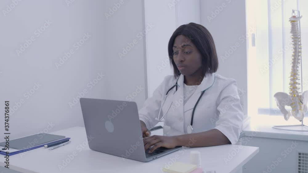 Female doctor suffering from headache, working on laptop in office, health Female doctor suffering from headache, working on laptop in office, health