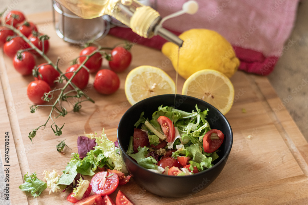 Preparación de ensalada de tomates y verdes, aceitando