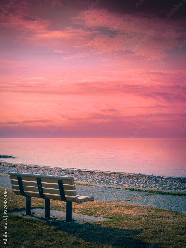 Tranquil Pink Twilight Seascape and Dramatic Cloudscape over the Bench on Cape Cod Beach