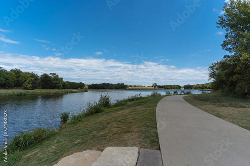 A concrete path in a Texas city park on a sunny August day.