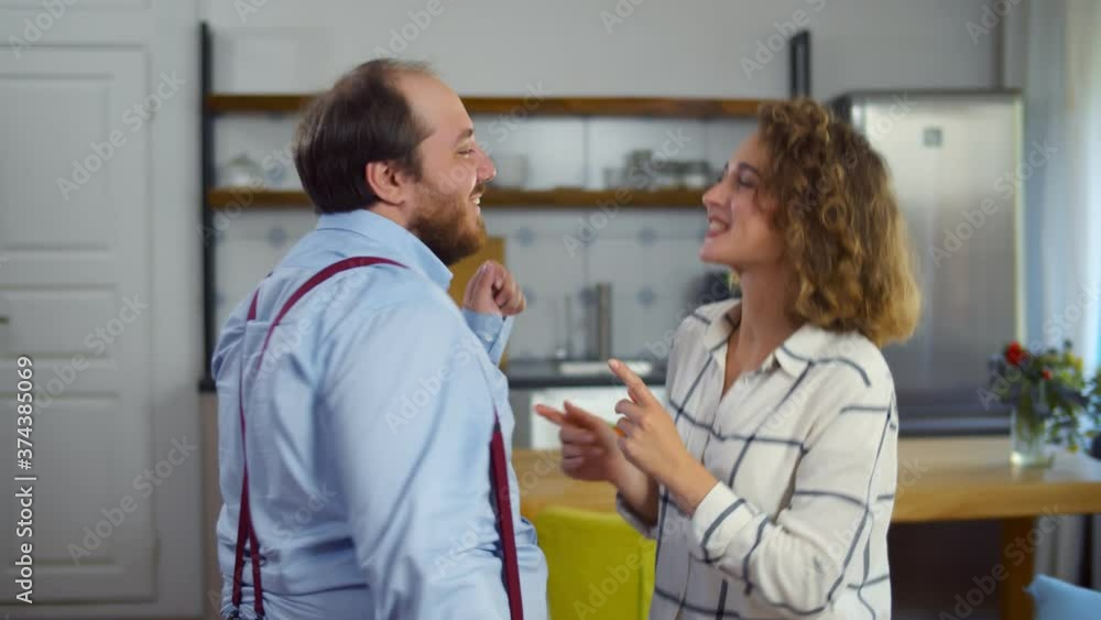 Side view of happy funny young couple dancing at home Side view of happy funny young couple dancing at home