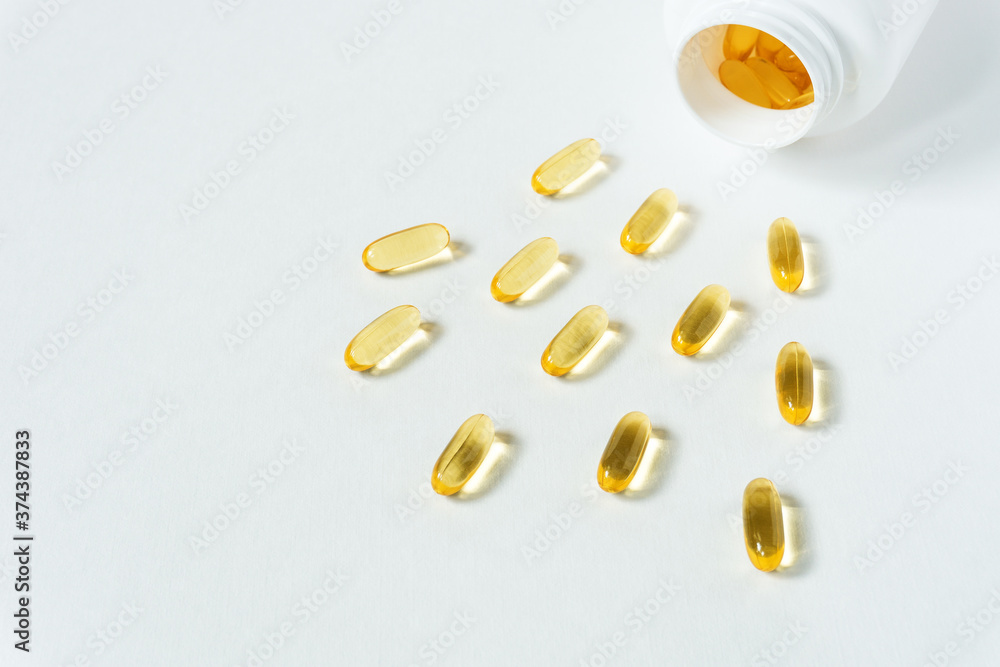 Top view of yellow capsules spilling out of plastic bottle. Selective focus. Top view of yellow capsules spilling out of plastic bottle. Selective focus.