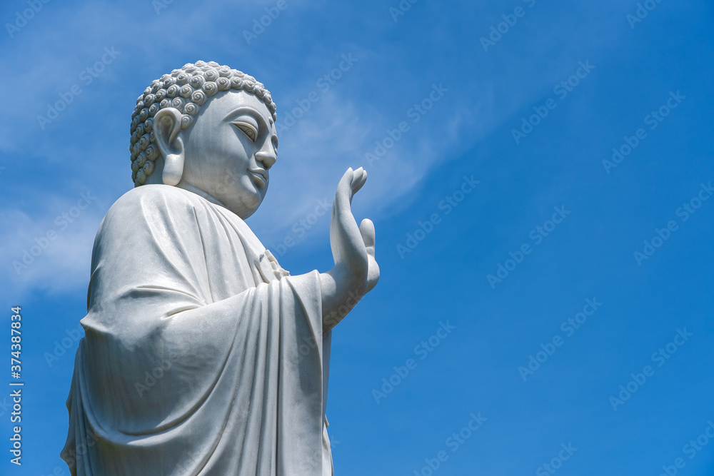 Detail of Buddha statue in a Buddhist temple and blue sky background in Danang, Vietnam. Closeup, copy space