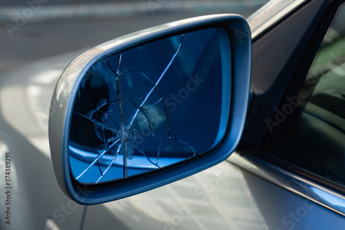 Broken car rearview mirror. Cracks in the glass. Broken left side mirror.