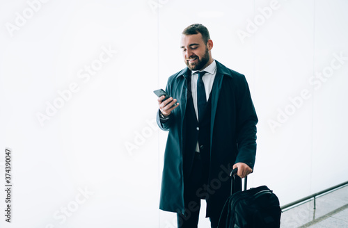Stylish businessman with smartphone in hand in airport