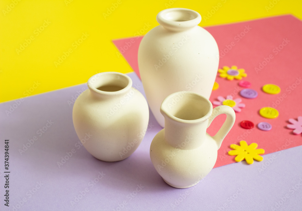 White clay vase on a bright colored background. Clay vessel for hand painting. Handmade. White clay vase on a bright colored background. Clay vessel for hand painting. Handmade.