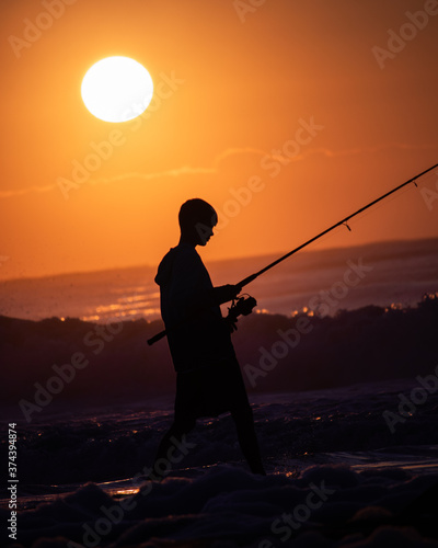 silhouette of a man fishing at sunset © Aidan
