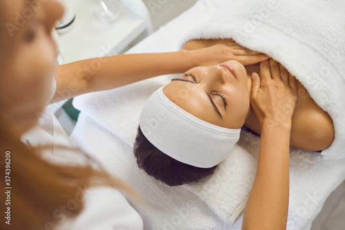 Masseur making massage of face and neck for serene woman