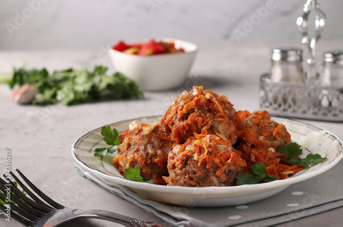 Meatballs with rice and minced in tomato sauce in plate on light gray background, horizontal format