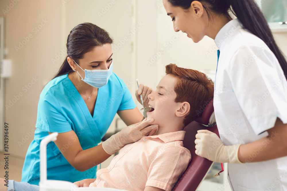 Dentist and assistant check the teeth of a boy child in a dental clinic. Dentist and assistant check the teeth of a boy child in a dental clinic.