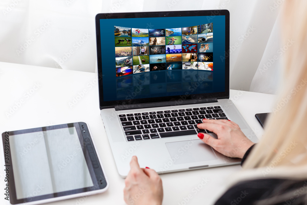 An ordinary workplace of a blogger with a modern laptop and an interface of an application for video editing process. An ordinary workplace of a blogger with a modern laptop and an interface of an application for video editing process.
