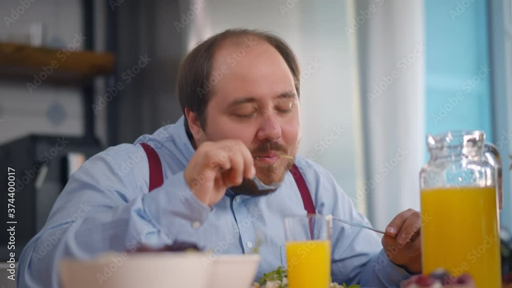 Portrait of overweight man having healthy breakfast in modern kitchen Portrait of overweight man having healthy breakfast in modern kitchen