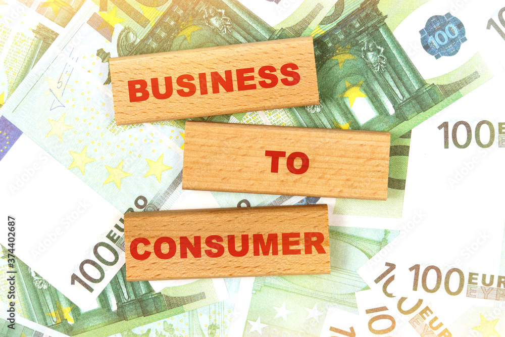 Against the background of euro bills, the text is written on wooden blocks - Business to consumer Against the background of euro bills, the text is written on wooden blocks - Business to consumer
