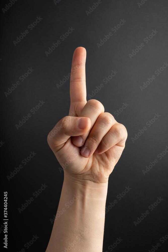 Woman hand with the index finger pointing up