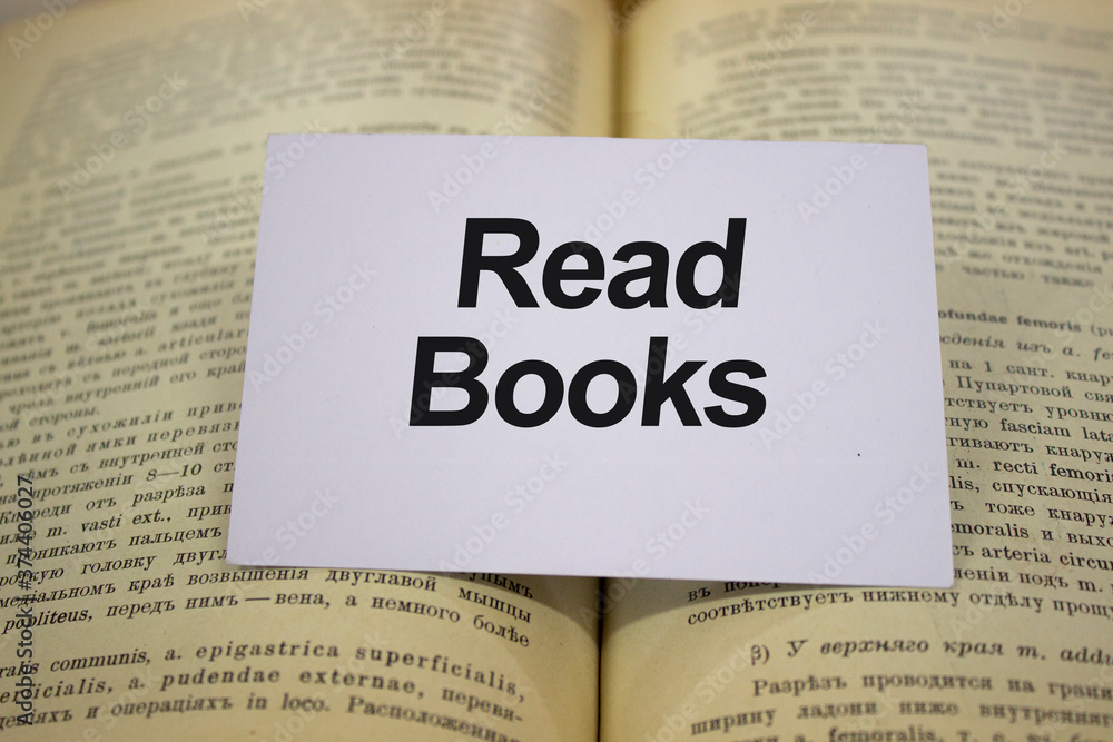Read books written in white note on open book Read books written in white note on open book