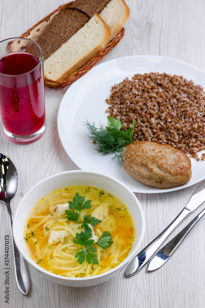 Business lunch with soup, buckwheat with cutlet, piece of meat and juice. Top view. Business lunch with soup, buckwheat with cutlet, piece of meat and juice. Top view.
