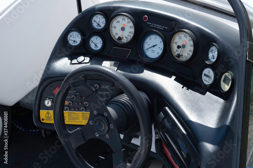 The cockpit of a speedboat showing all the gauges and steering wheel