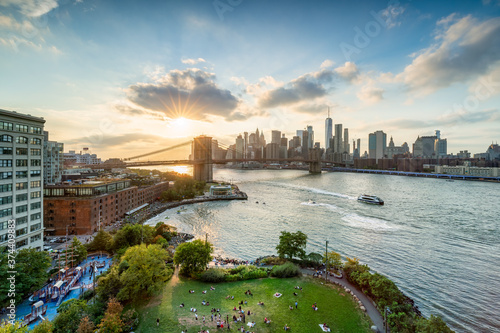 View of Brooklyn Bridge and Manhattan skyline at sunset, New York City, USA