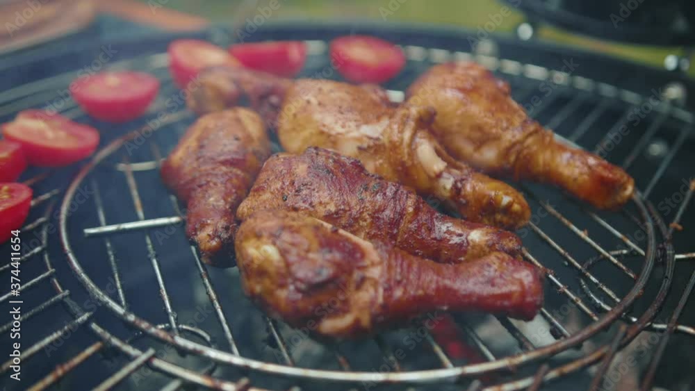 Man turning appetizing meat chicken wings and legs on metal charcoal griller brazier cooking delicious food for barbecue picnic with family. Close-up footage. Man turning appetizing meat chicken wings and legs on metal charcoal griller brazier cooking delicious food for barbecue picnic with family. Close-up footage.
