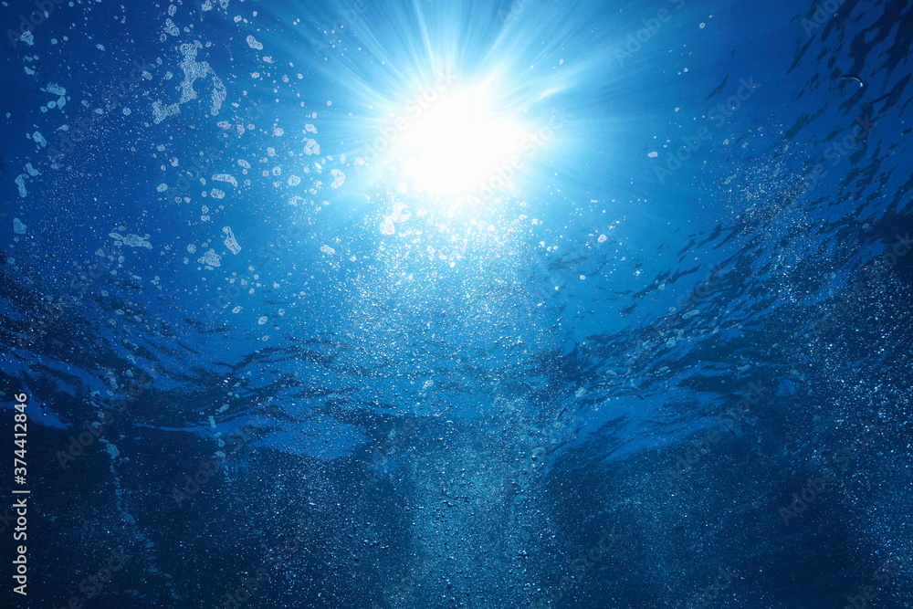 Sunshine with air bubbles underwater in the ocean, natural scene