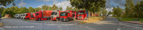 Panorama of logistics trucks on the motorway rest area. Ban on Sunday driving .Trucks at motorway service areas at Sunday.