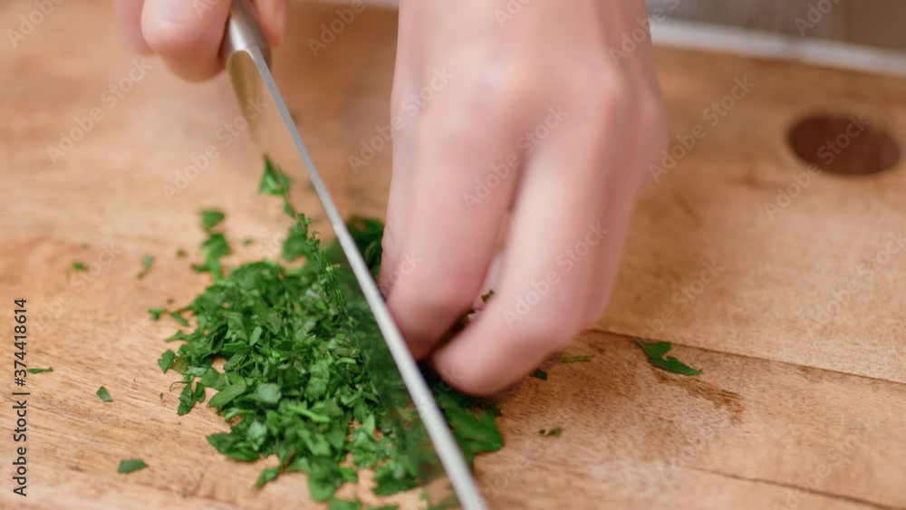 Chopping parsley, greens on cutting wooden board in 4K. Concept of preparing ingredients to cook shrimp/prawns. Chopping parsley, greens on cutting wooden board in 4K. Concept of preparing ingredients to cook shrimp/prawns.