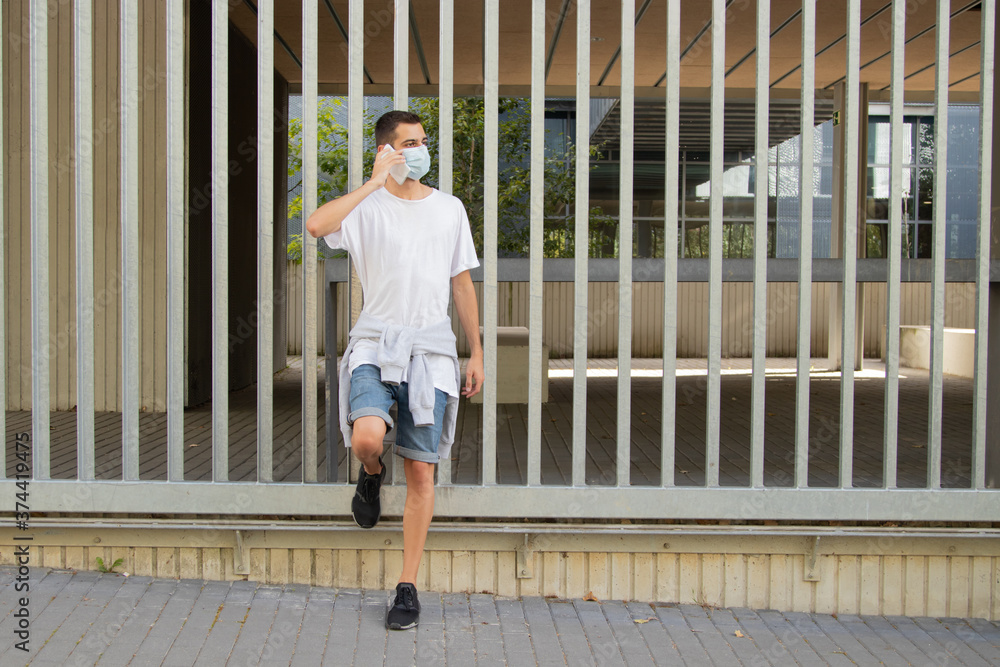 young man in the city with mask and mobile phone young man in the city with mask and mobile phone