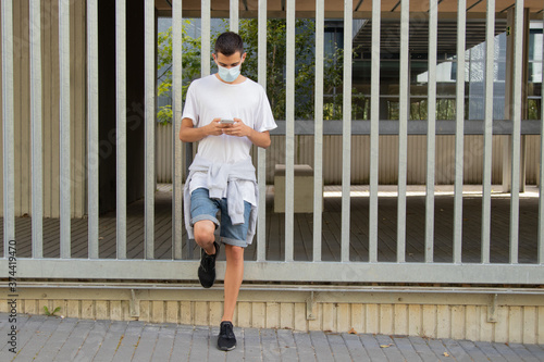 young man in the city with mask and mobile phone © carballo