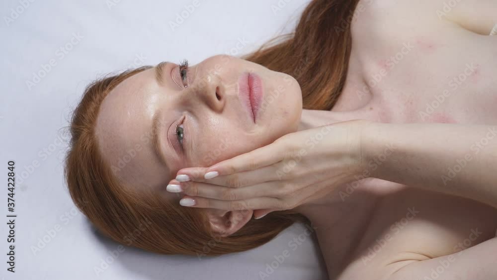 Woman after a cosmetological procedure takes off her glasses and strokes her face. Woman after a cosmetological procedure takes off her glasses and strokes her face.