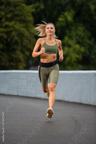 Sport Ideas. Caucasian Female Runner In Professional Outfit During Her Regular Training Exercises Outdoor.