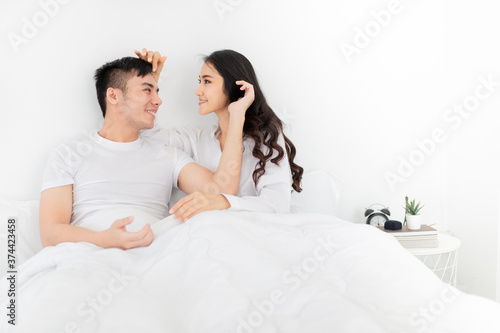 asian lover rest on bed, asian man use hand touch hair of his wife in bedroom, they feeling love and happy together, happiness honeymoon and valentine's day