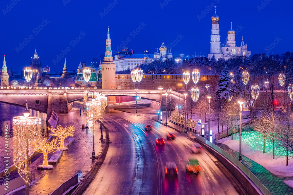 Moscow. Russia. Kremlin embankment on a winter evening. Moscow view from the drone. Cars ride on a winter road. New Year Kremlin Christmas decorations on lanterns and trees. Guide to Russia
