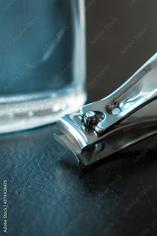 Metal nail clipper and men beauty tools on a black wooden table Metal nail clipper and men beauty tools on a black wooden table