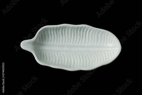 Small leaf shaped plate isolated on black background, top view image.