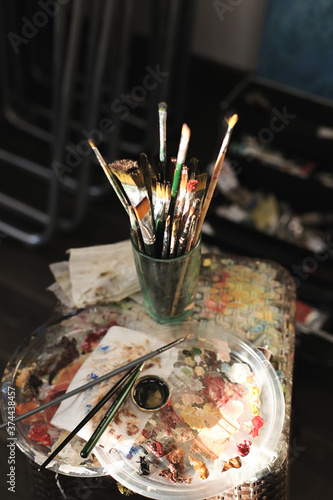 brushes in a glass for oil painting in the artist's studio