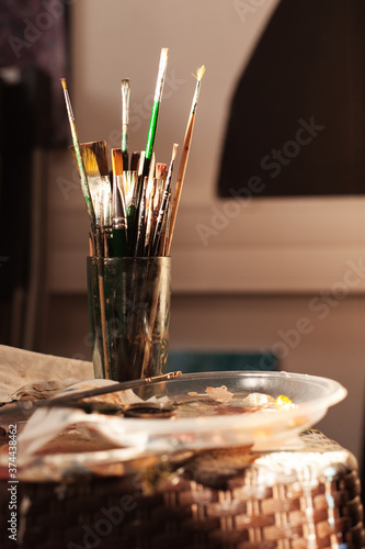 brushes in a glass for oil painting in the artist's studio