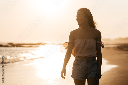 Smile Freedom and happiness chinese woman on beach. She is enjoying serene ocean nature during travel holidays vacation outdoors. asian beauty. summer time #374442027