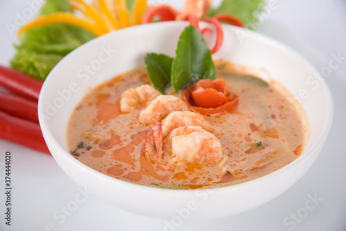 Tom Yam kung Spicy Thai soup with shrimp, seafood, coconut milk and chili pepper in bowl copy space