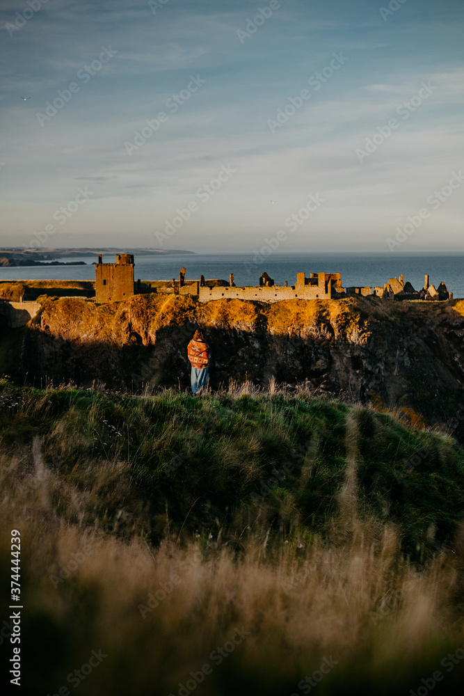 person in front of castle near the sea