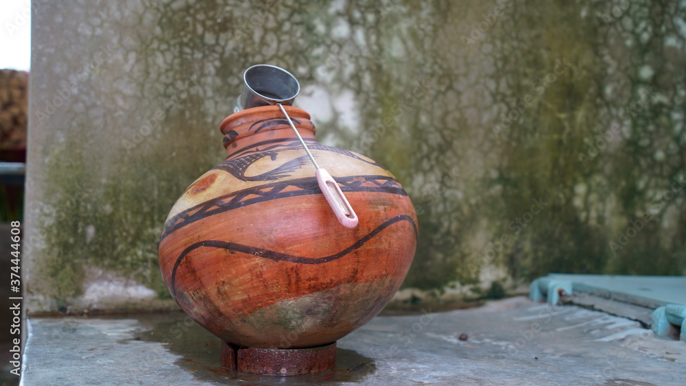 Red Clay pot with stainless steel glass in a house corner. Stylish printed art, ancient India culture to make pot.
 - obrazy, fototapety, plakaty 