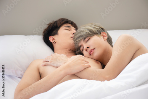 LGBT concept gay couples love Asian men cuddling in bed.