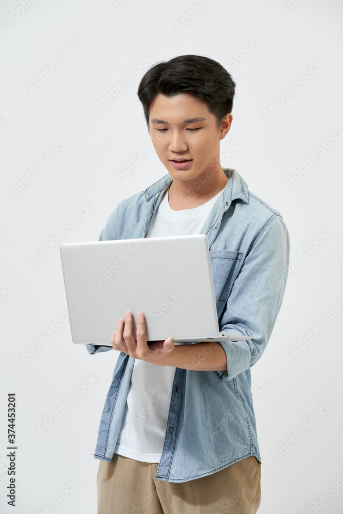Young male student using laptop isolated on white background. Young male student using laptop isolated on white background.