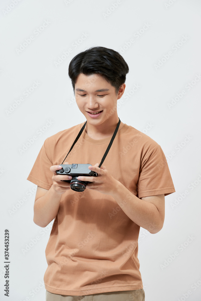 Attractive handsome young Asian man using camera over white background. Attractive handsome young Asian man using camera over white background.